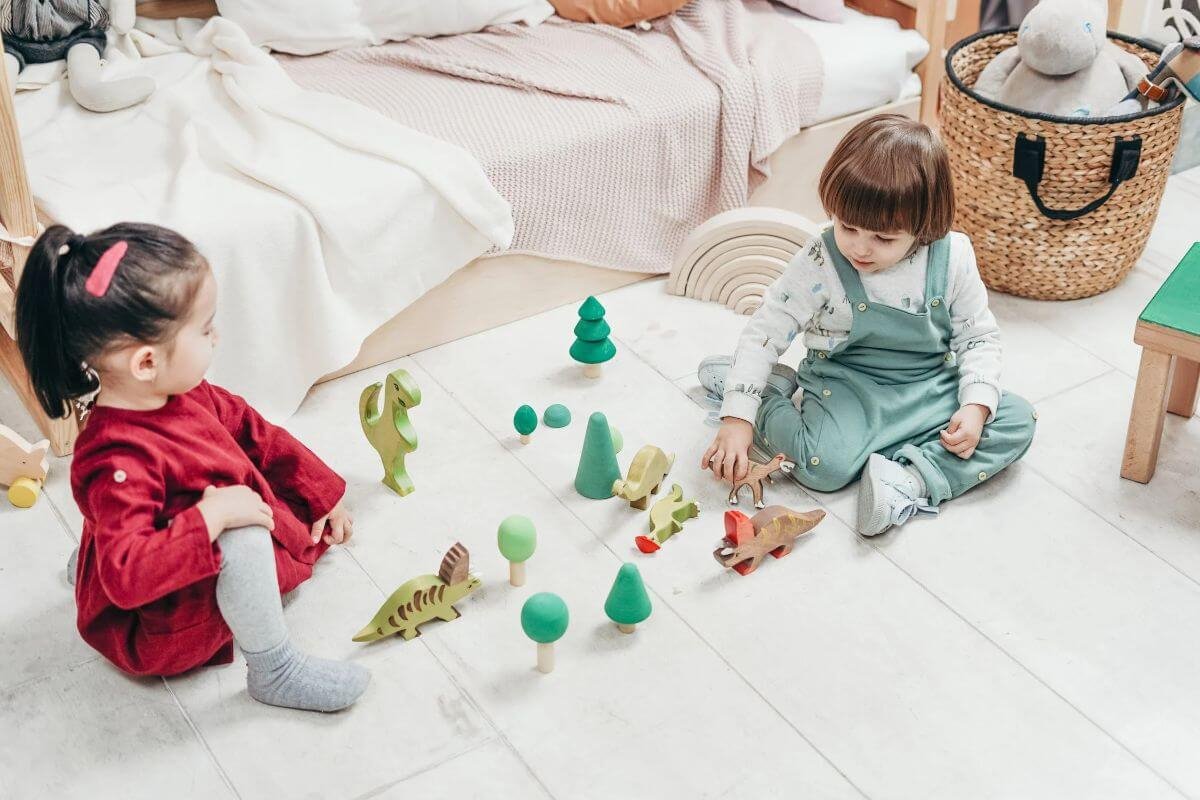 Cadouri pentru copii de Craciun-doi copii cu figurine pe podea