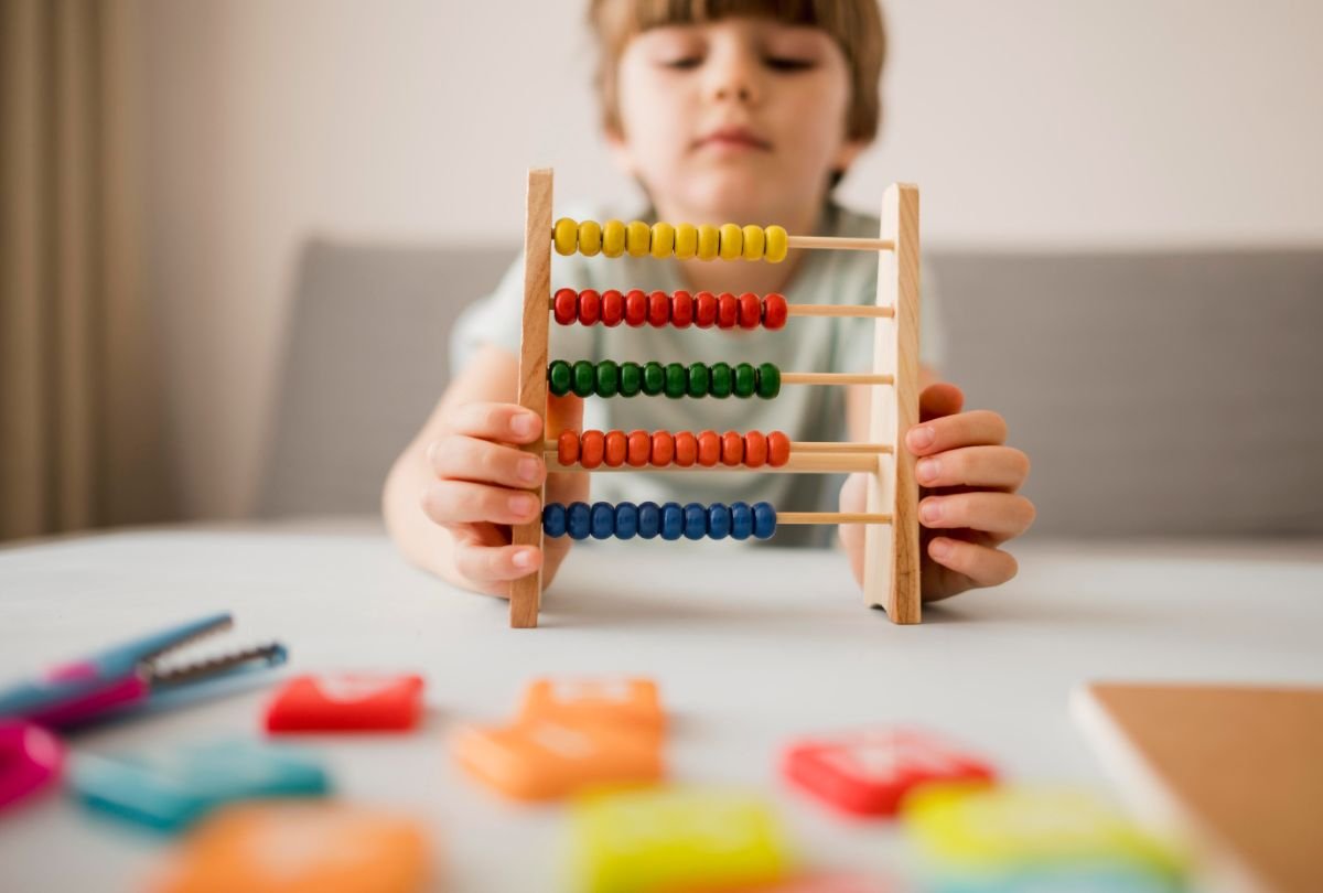 Dezvoltarea psihomotorie la prescolari - baietel care se joaca cu un abac